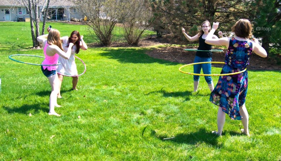 Hula hooping. Teen girls hula hooping at a family get together.