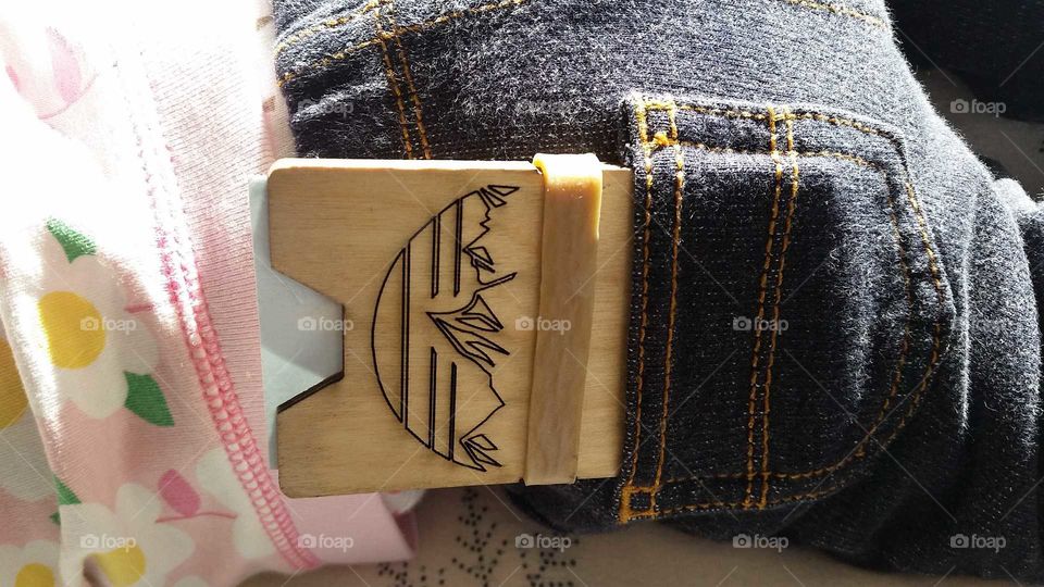wooden credit card holder in a baby's back pocket. baby's jeans got pockets.  baby got all my money