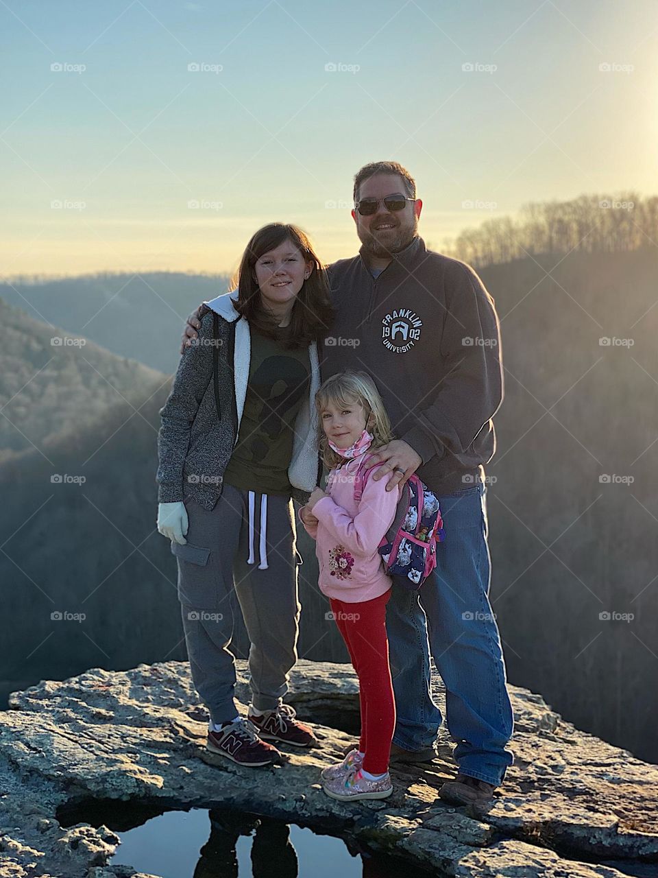 A dad and his kids enjoying the view after a hike in the woods of Kentucky 