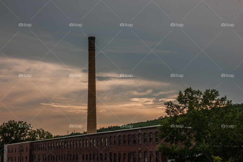 Old mill with chimney shooting up into sky