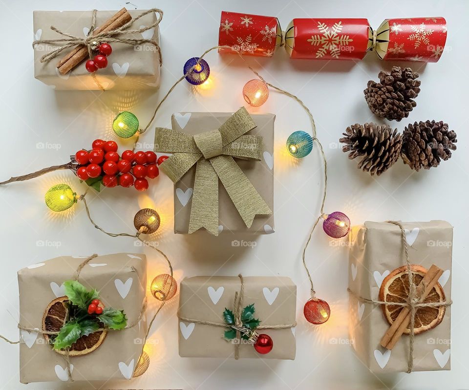 Brown paper packages tied up with string and natural themed decorations, with coloured lights