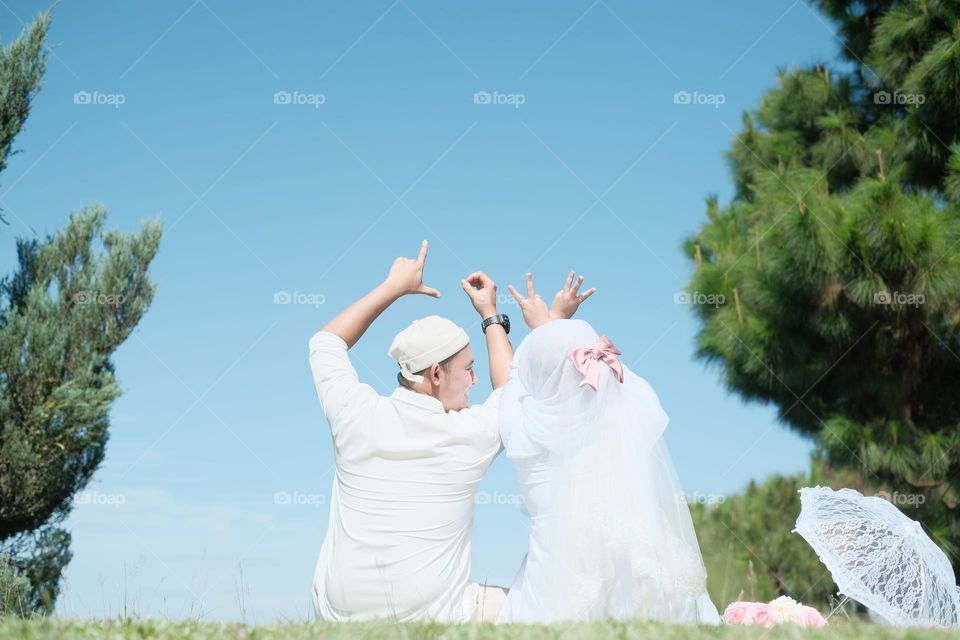 couples of newly weds wearing all white for an outdoor photoshoot.