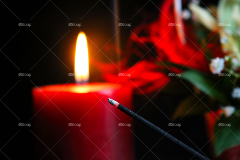 Red candle, flowers and scented stick