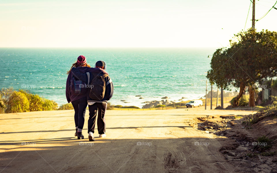 Two young friends walking together on their way to a new adventure at the beach 