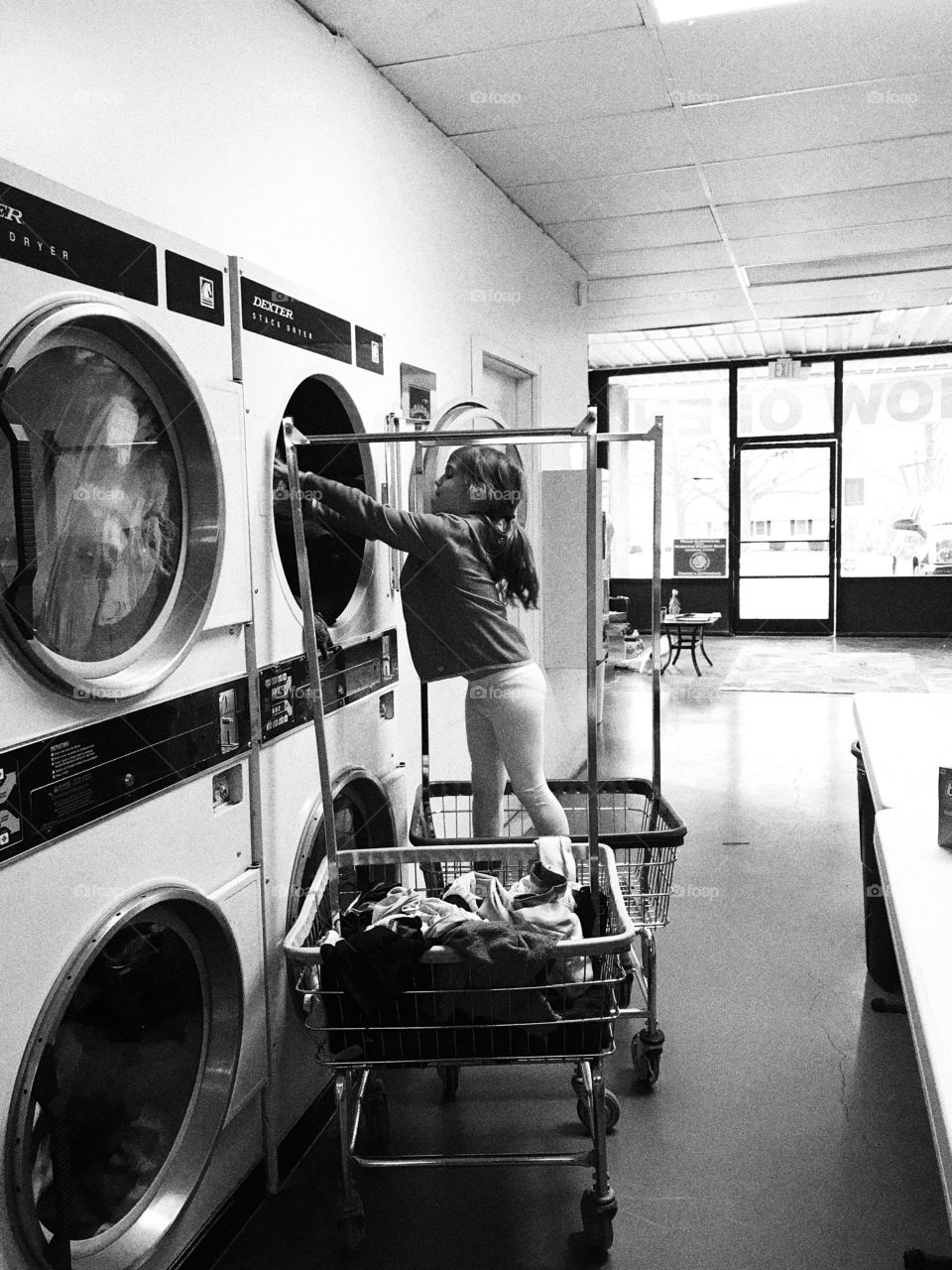 Child helping parent at laundry mat 