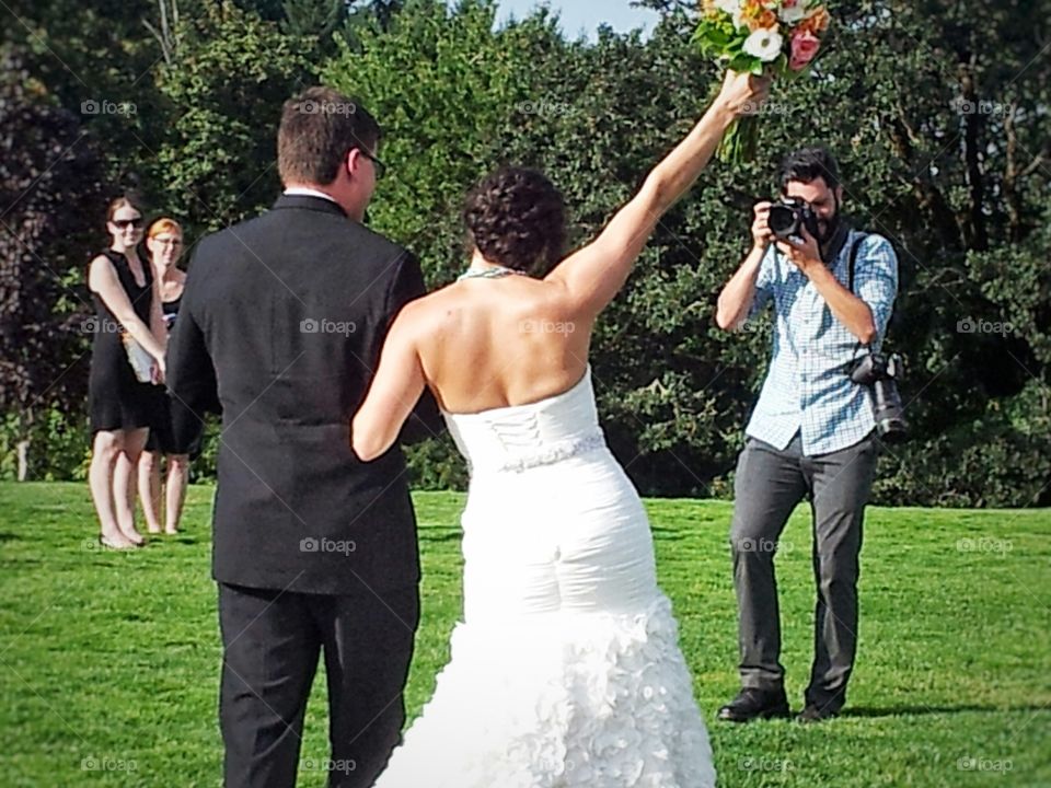 Photographer Taking Photos While Walking Backwards at Celebrating Bride