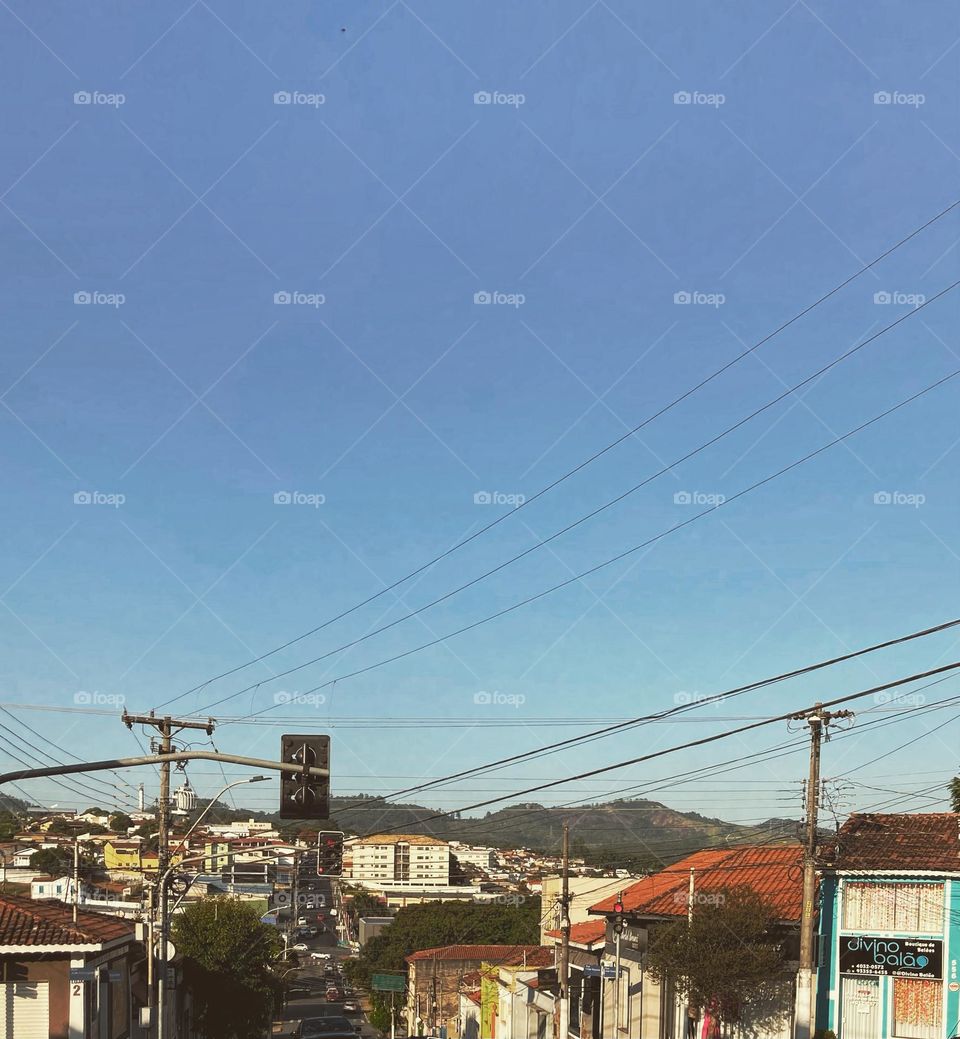 🇺🇸 A bucolic scene of everyday life: the dawn of the city between the wires and the houses / 🇧🇷 Uma bucólica cena do cotidiano: o amanhecer da cidade entre os fios e as casas. Prefiro a vista ao longe, do horizonte azul e o mato bem verde. E você?