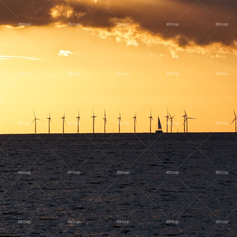 Distant view of sailboat during sunset