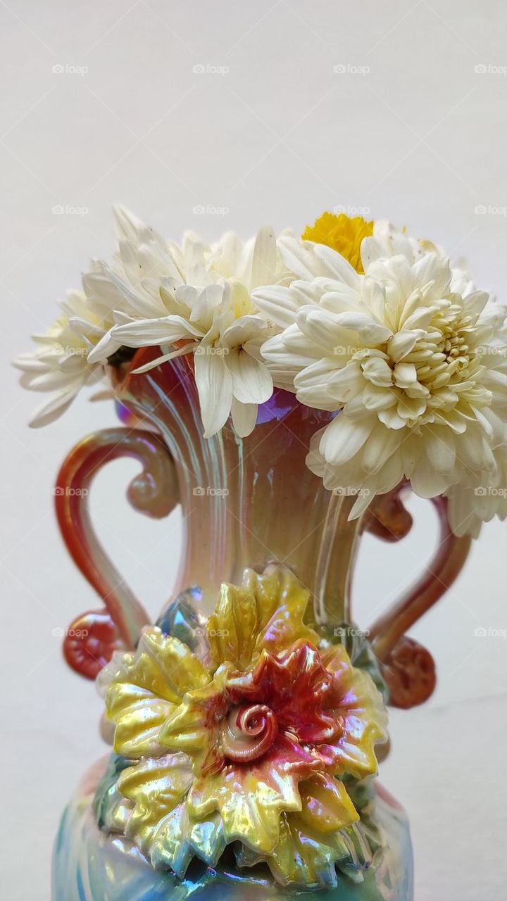 Beautiful white flowers in a colourful flowerpot with a flower sculpture, Flowers in a vase, colourful vase, white flowers in a vase