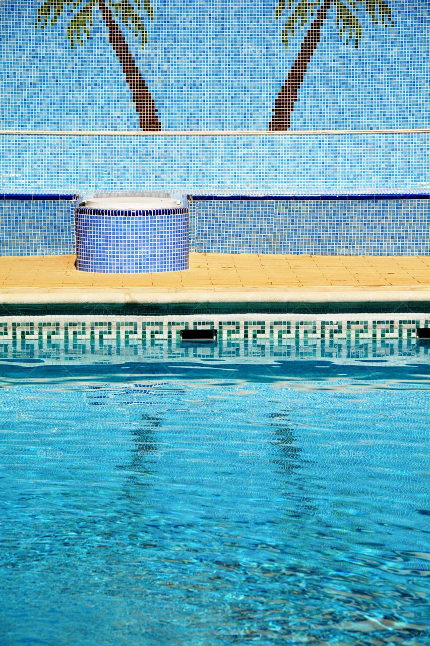 a swimming pool and two palm trees made with small tiles
