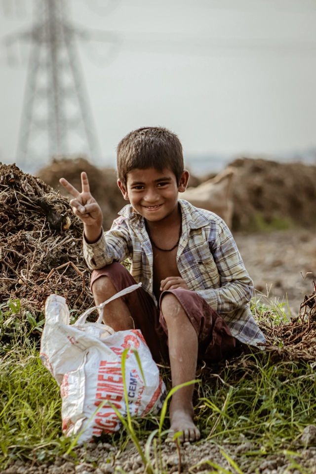 In this photo it is said that a boy is very happy who is taking the photo with two fingers showing his happiness.