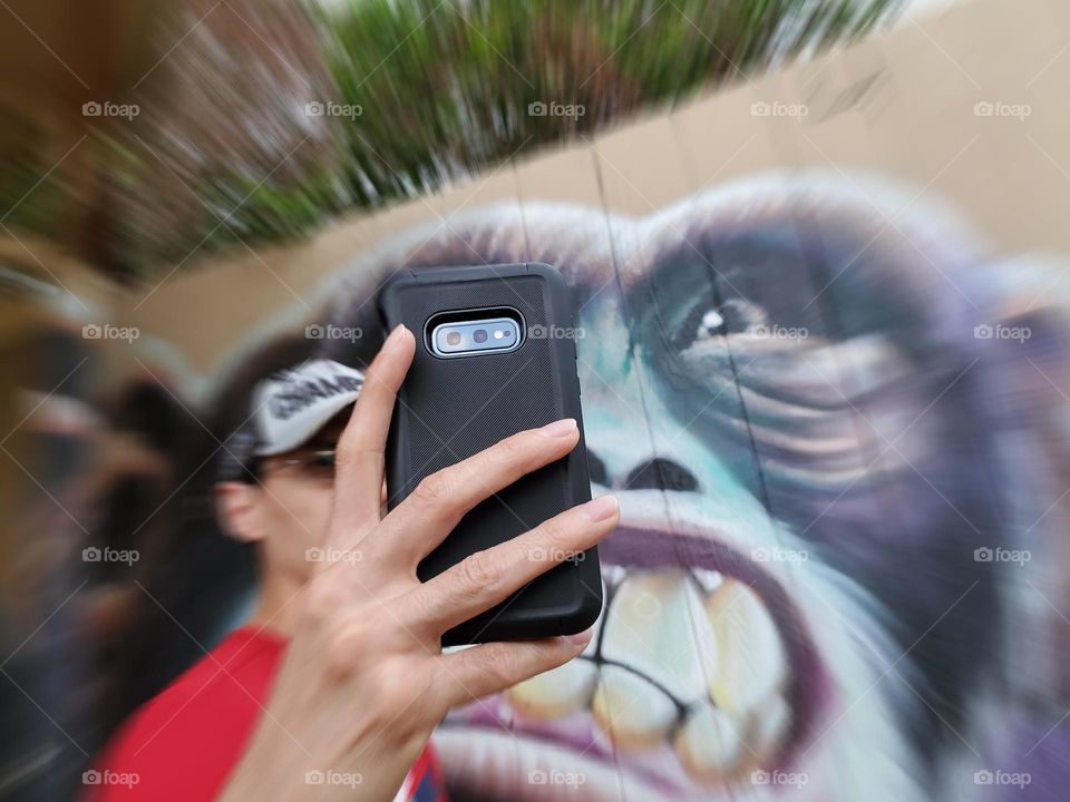 Taking a selfie during the foap street art mission with street art of an angry ape/monkey.