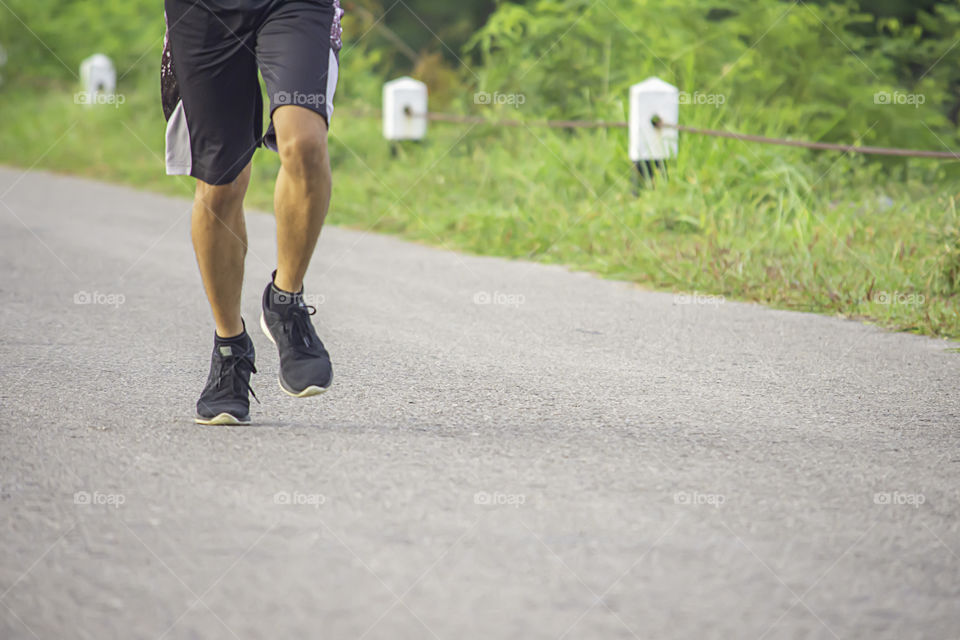 The men are running on the road Background trees.