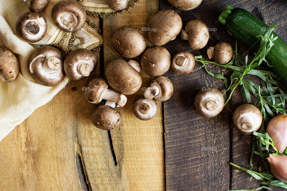 Preparation for making dinner beautiful elegant fresh vegetable ingredients foodscape of mushroom, fresh tarragon herbs, shallot and zucchini on rustic wood with linens