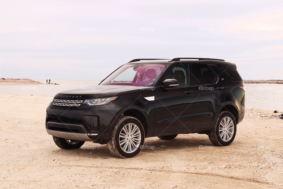 Black 2017 land rover discovery suv offroad on beach with fishermen, jetty park, matagorda texas