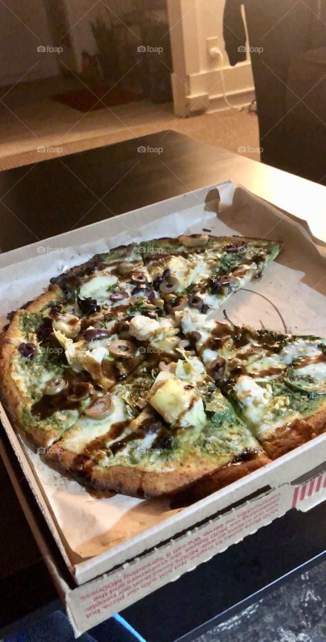 Pizza with mozzarella, parmesan, artichoke, roasted garlic cloves, greek olives, arugula, pesto, a balsamic fig glaze, and cauliflower crust. 