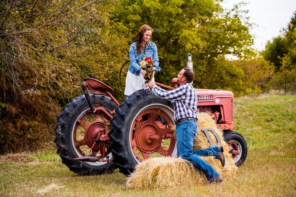 Couple in agricultural field near tractor