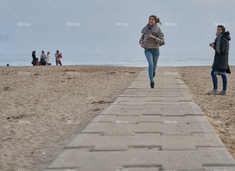 Woman running on walkway at beach