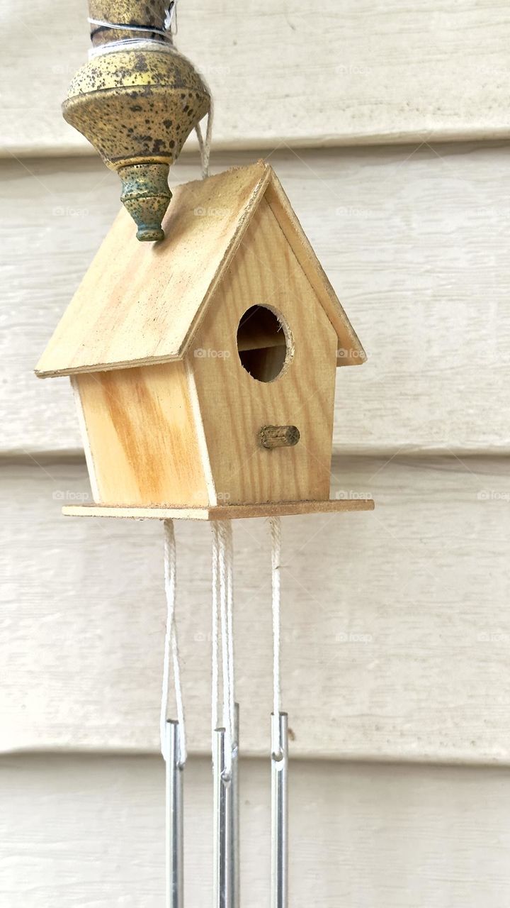 Bird house hanging on metal lamp.