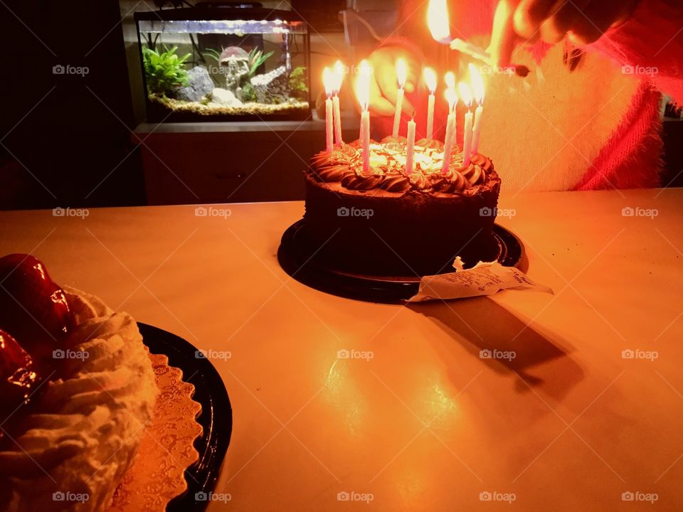 Girl lighting the candles on her birthday cake. 