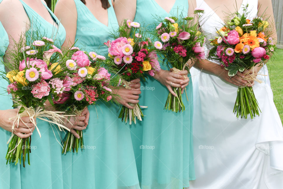 A bride and bridesmaids holding loose wildflower bouquets