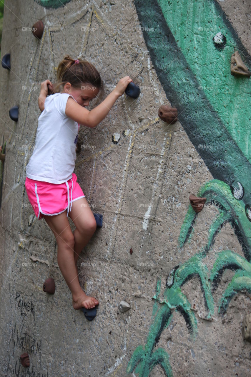 Girl Rock climbing . Young rock climber