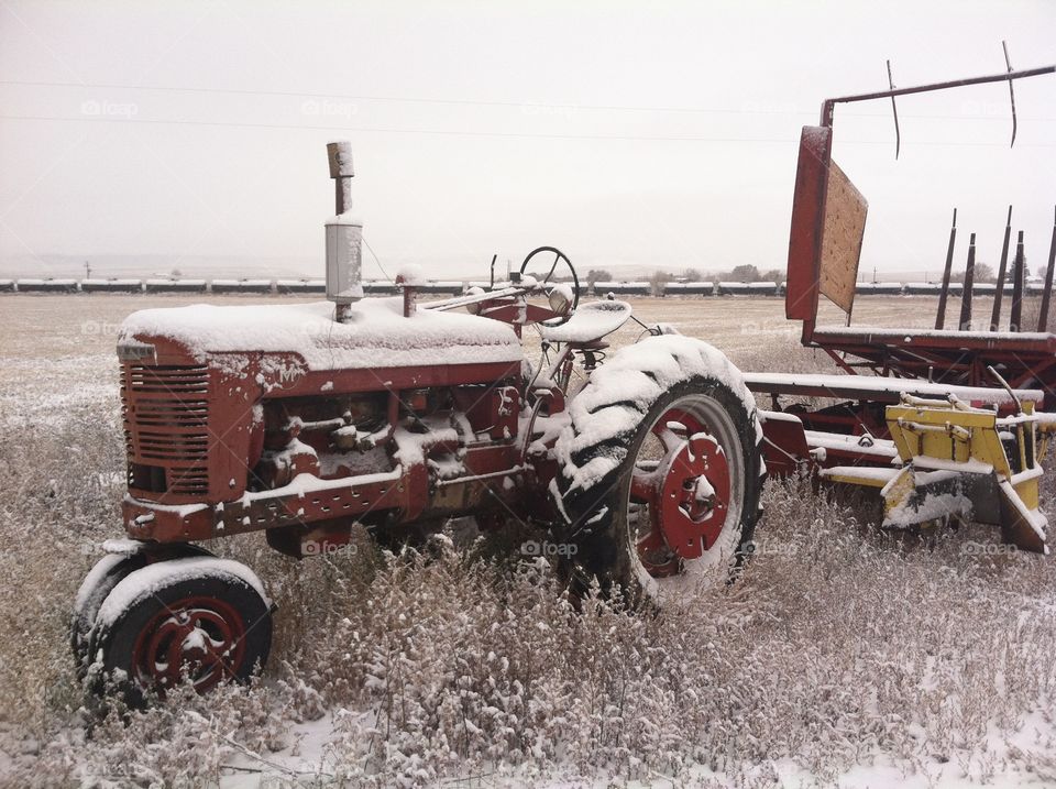 1951 Farmall M and new holland 1030 stack wagon covered in snow. 