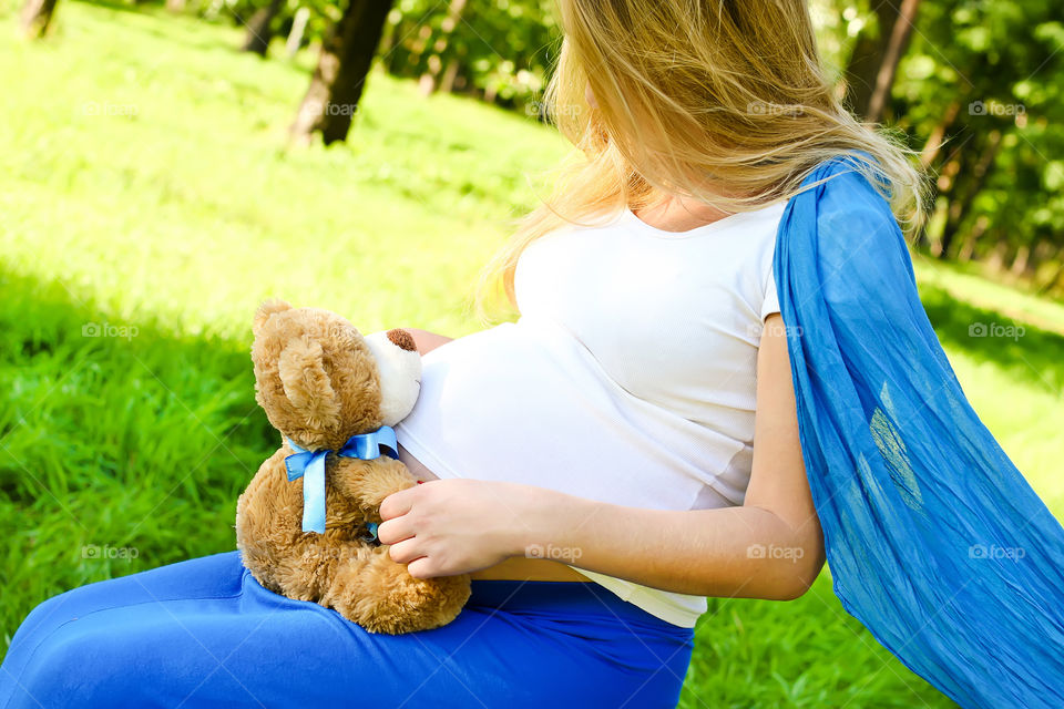 Pregnant woman holding teddy bear