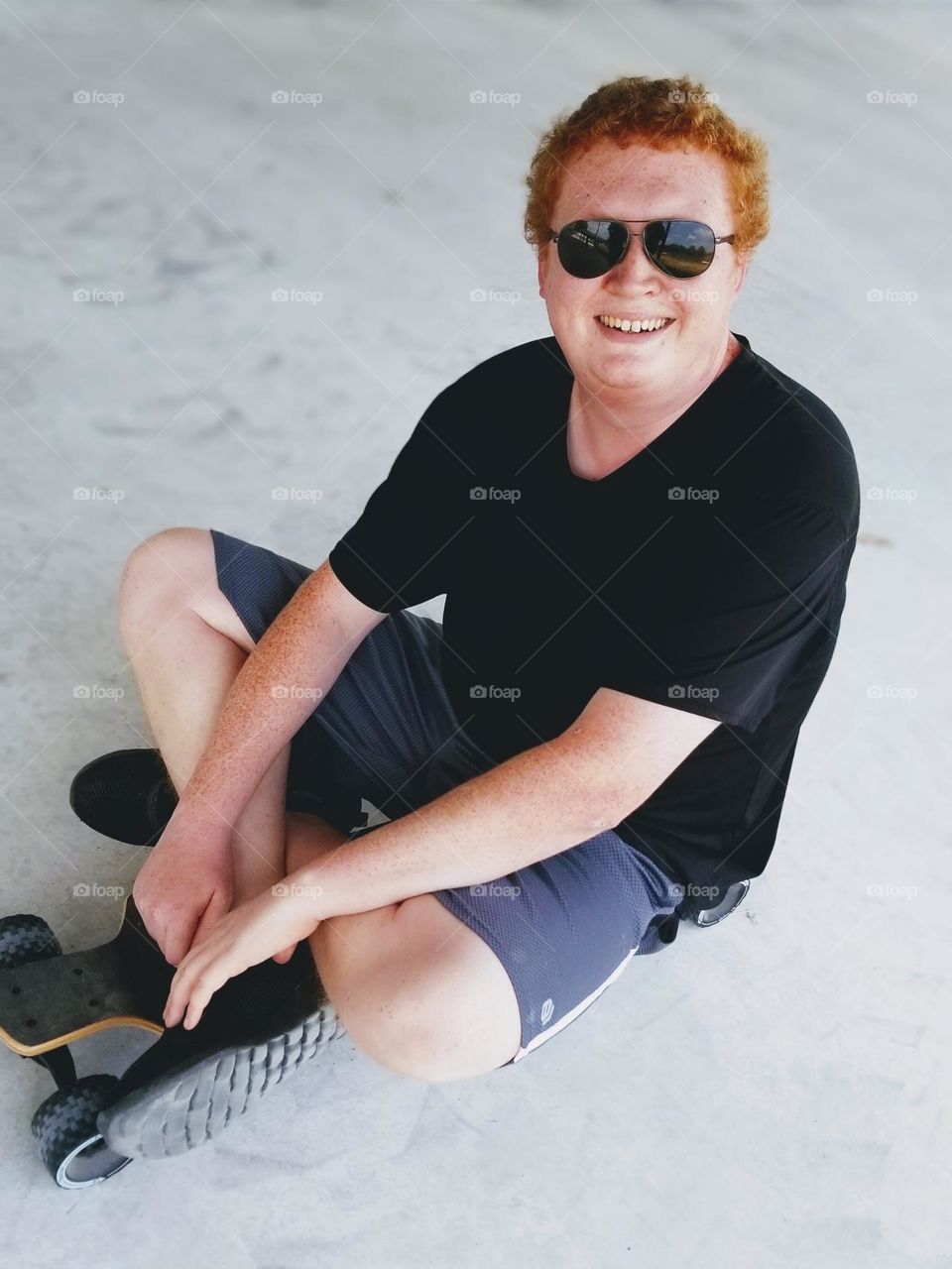 Happy Man Sitting on His Long Board