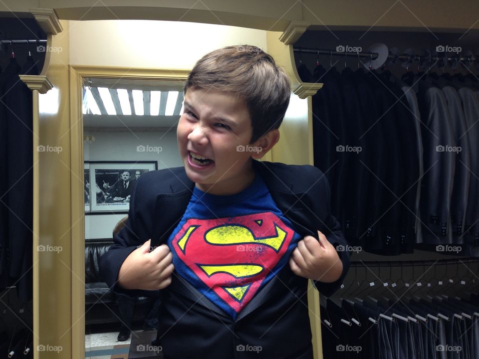 Superman kid. Kid in suit opens jacket to reveal superman logo