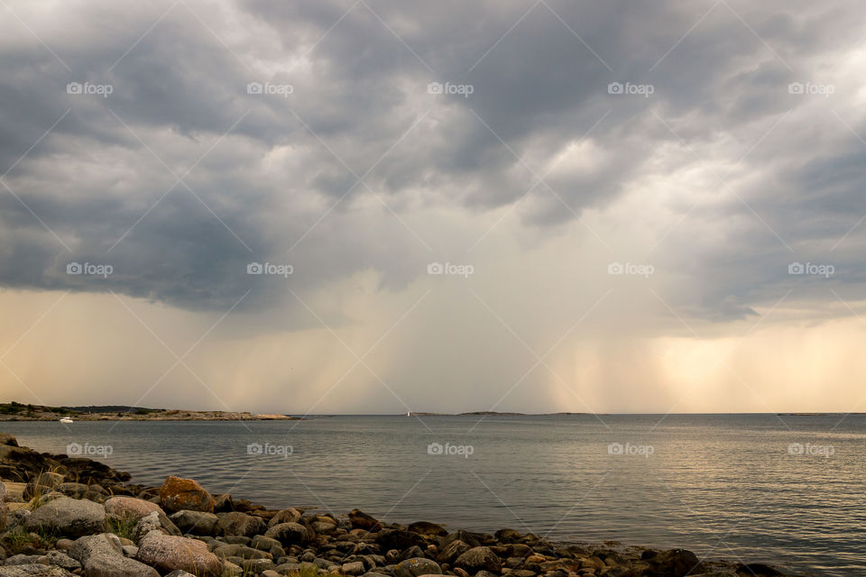 Bad weather with rain showers over the ocean is approaching the coast , oväder med regn över havet närmar sig kusten 