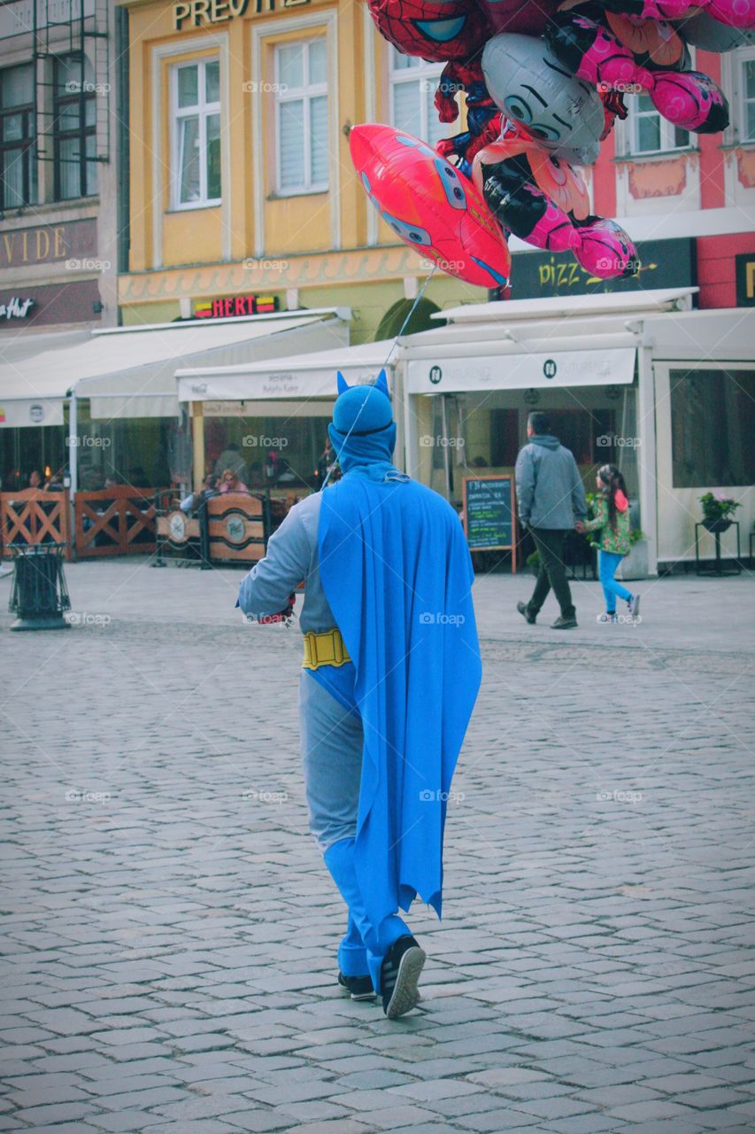 Batman selling balloons to help children in need. He's a real superhero!