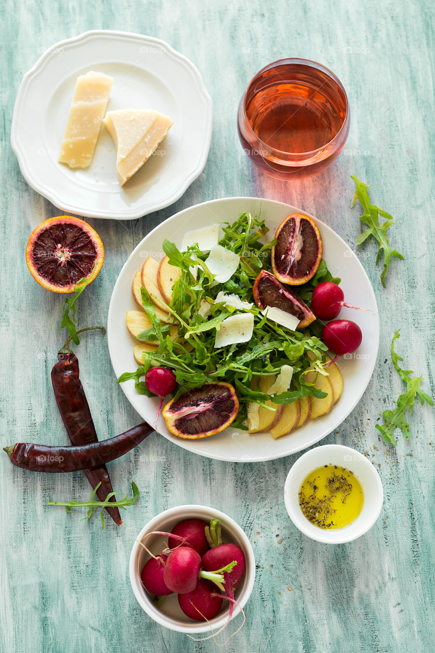 Salad with pear, red orange fruit and arugula leaves