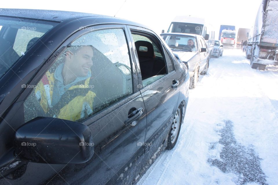 Traffic full of cars stuck in the field full of snow 