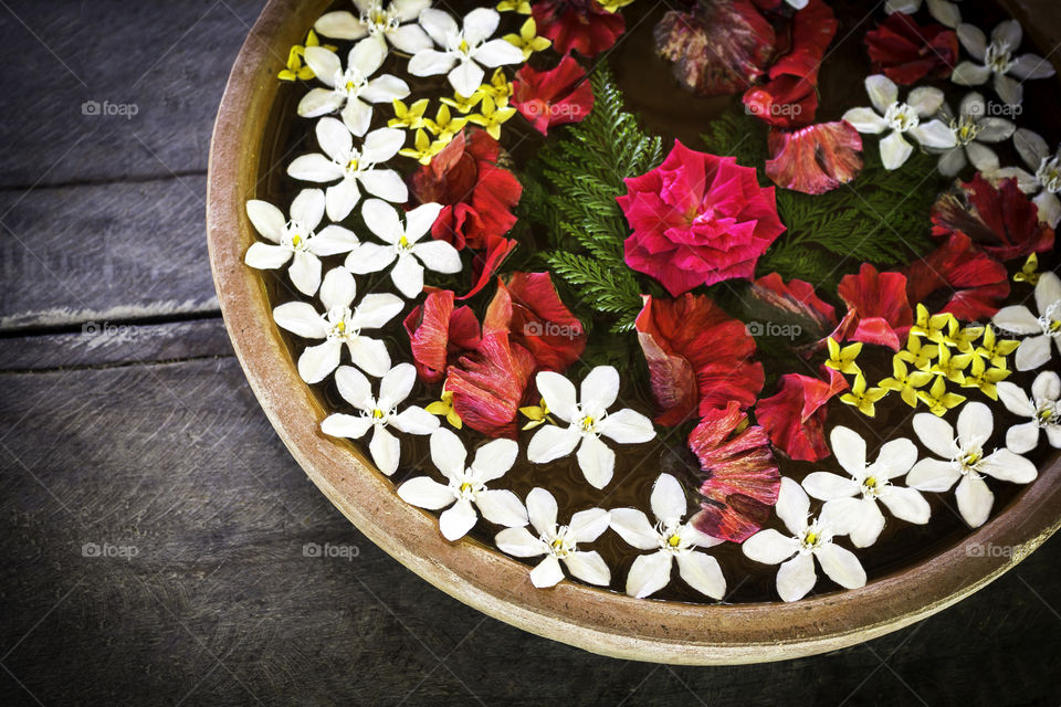 Spa therapy with flowers on water in bowl