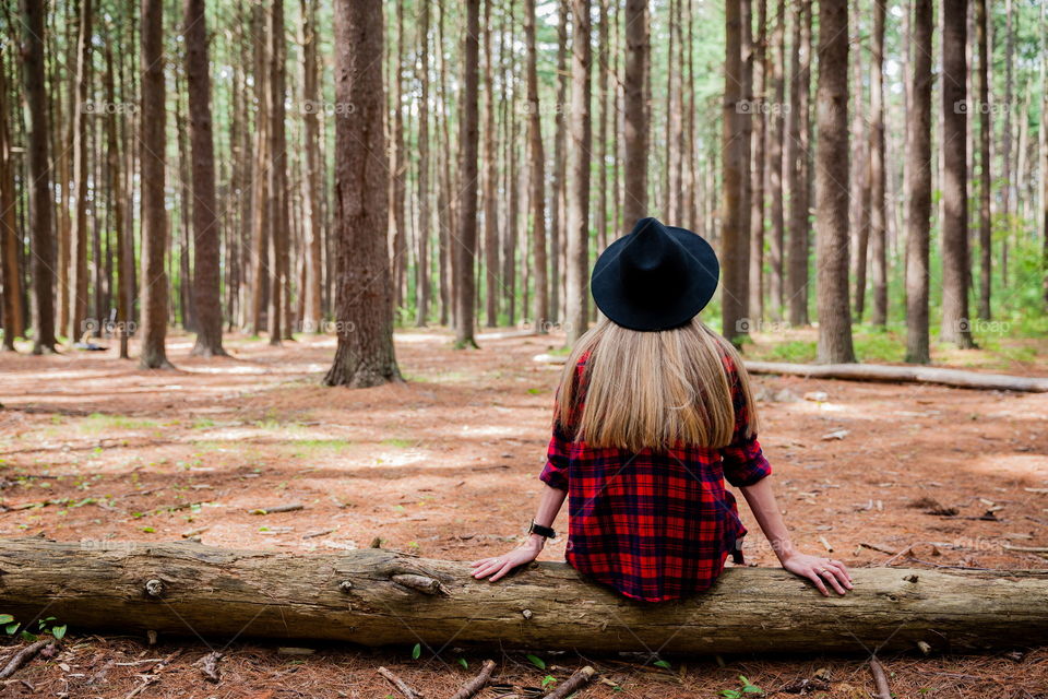 Girl sitting on log in the woods