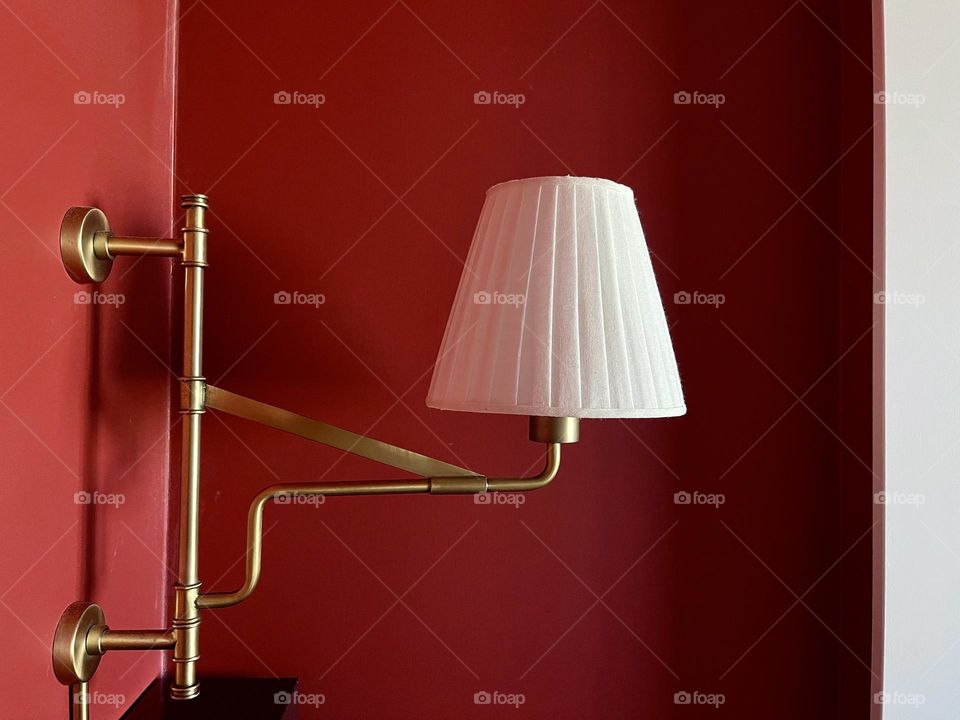 White retro wall lamp on the red wall background 