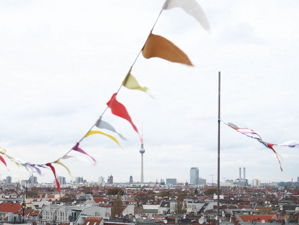 View over Berlin with colorful flags moving in the wind with the Berlin TV tower in the center.