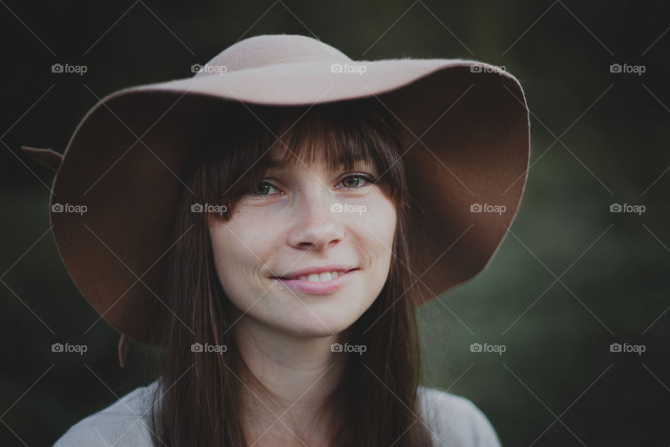 Portrait of Young woman in hat at evening park 