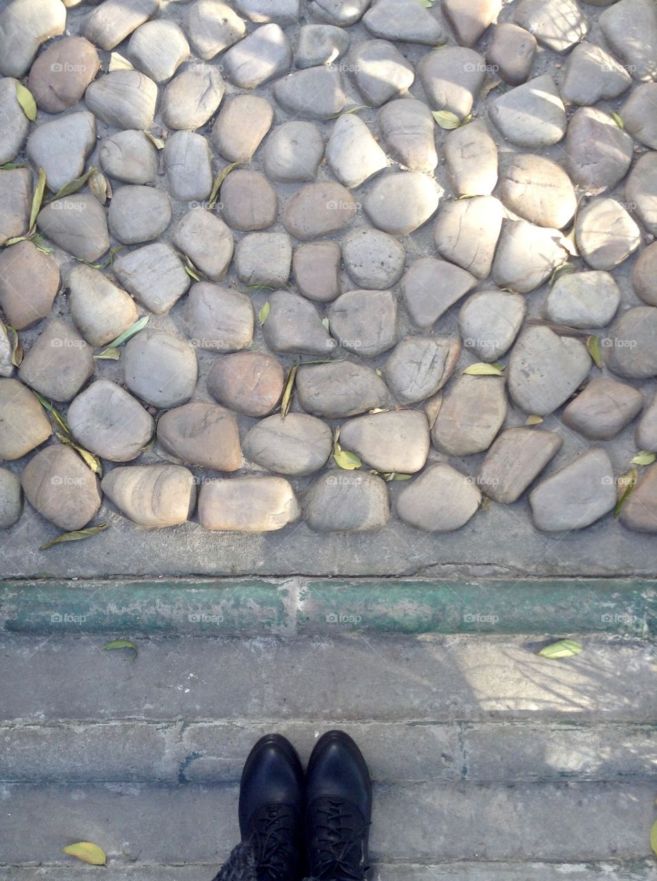 A walkway in park covered with stones and plates