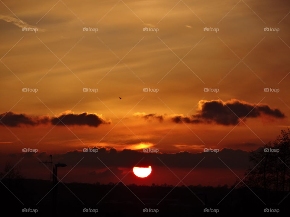 sunset. sunset today in  the city of Nottingham in Great Britain with a small helicopter above the dark clouds