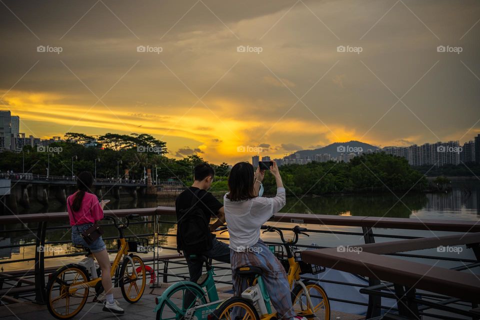 People are capturing the golden sky.