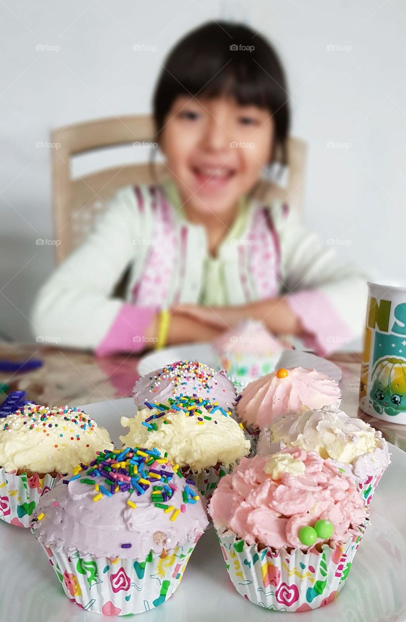 Happy little girl with cupcakes