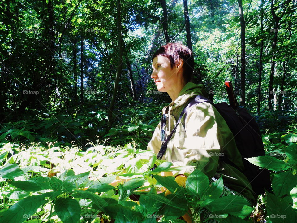 girl in a jacket and with a backpack in a magical forest