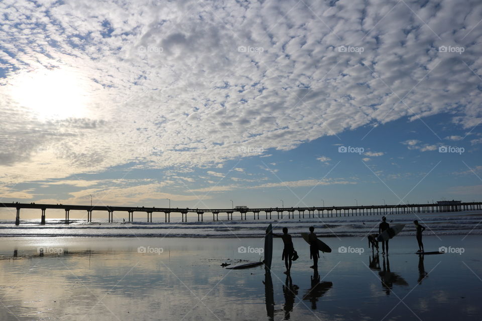 Young surfers talking on beach at dusk