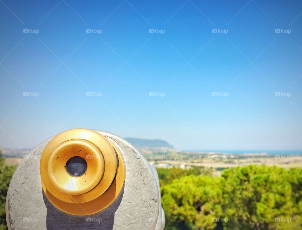 Close up of a telescope watching mount conero and the adriatic sea