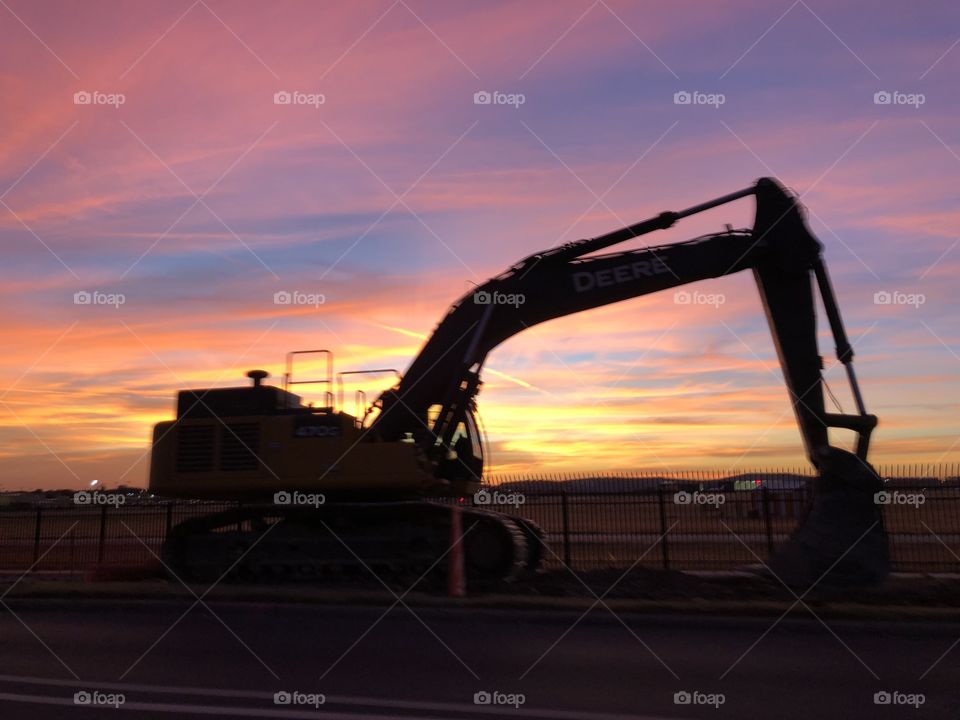 Sunset over Love Field Airport in Dallas TX behind some construction equipment 