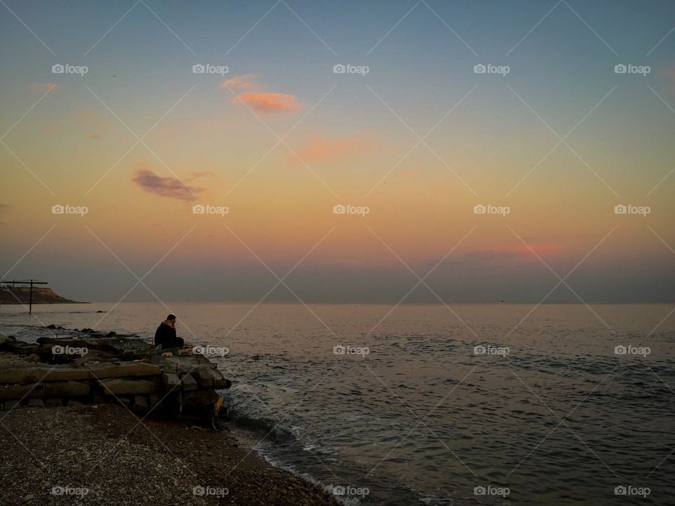 Sea sunset and the man on the rock 