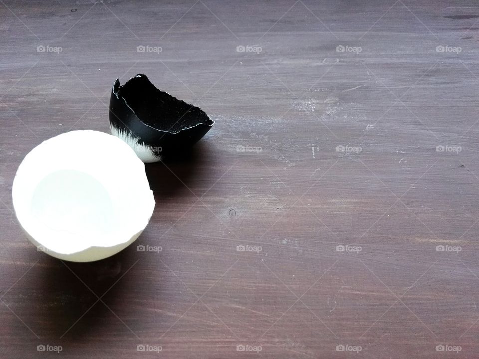 black and white cracked eggs on old wooden table