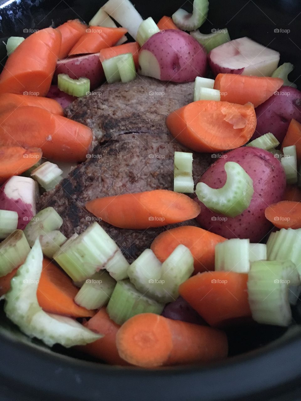 Meat and veggies prepared for slow cooking in the crockpot. 